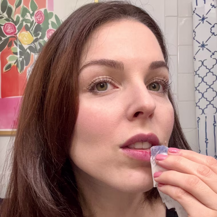 Wiping away the Wonderskin Wonder Blading Lip Stain Masque with a damp tissue.