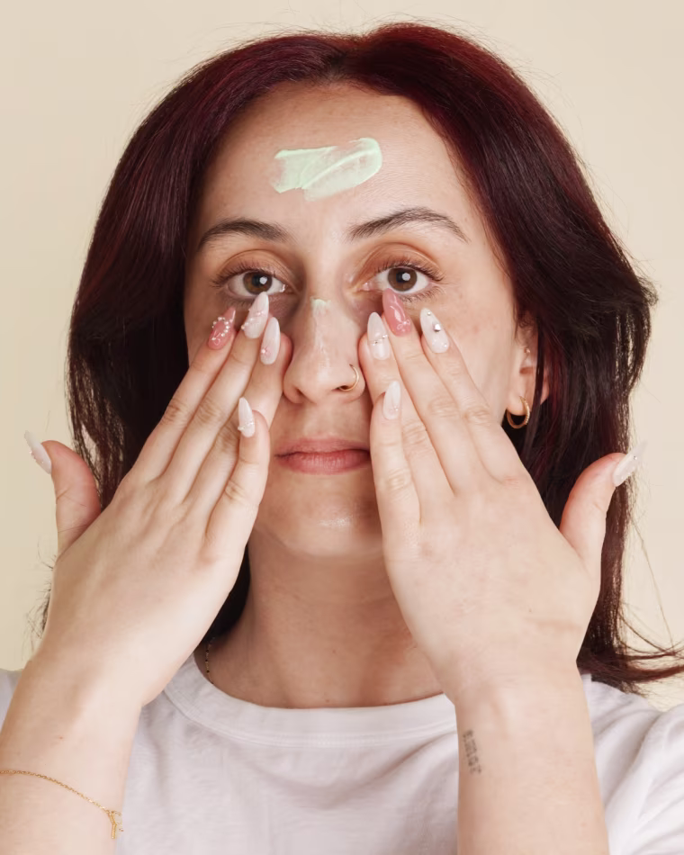 Woman blending EltaMD’s green color correcting formula into face