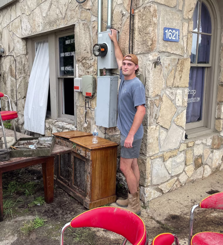 Christian Fell stands on the narrow top of a meter box