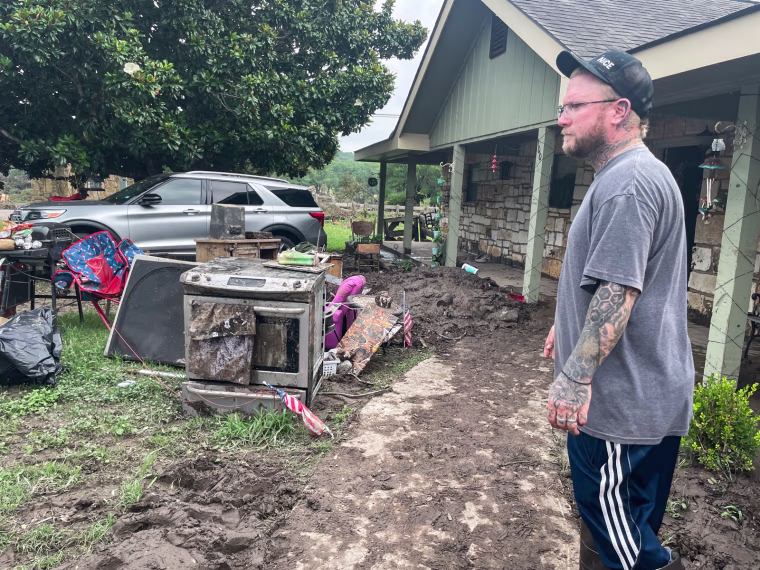 Matt Meagher stands in his flood damaged backyard
