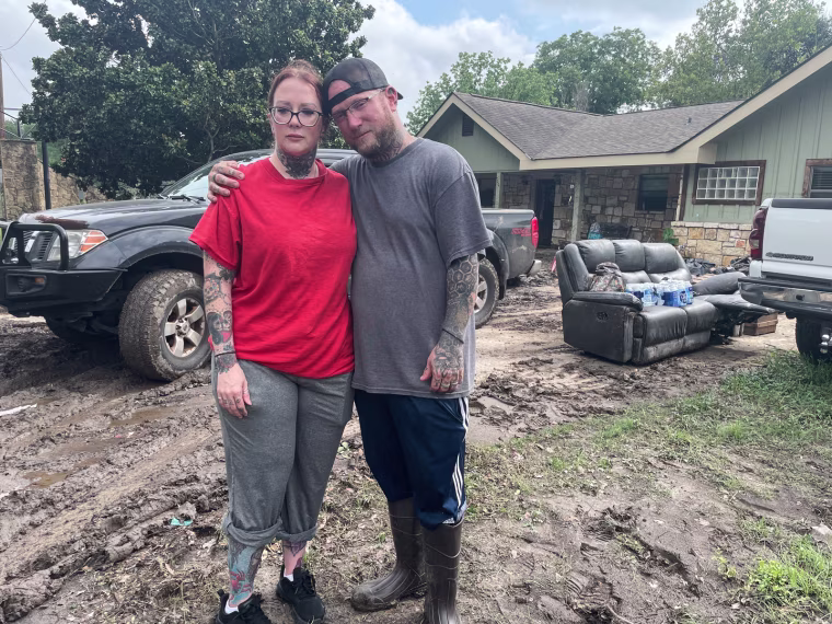 Erin Burgess, left, and Matt Meagher stand outside of a house and pose for a portrait