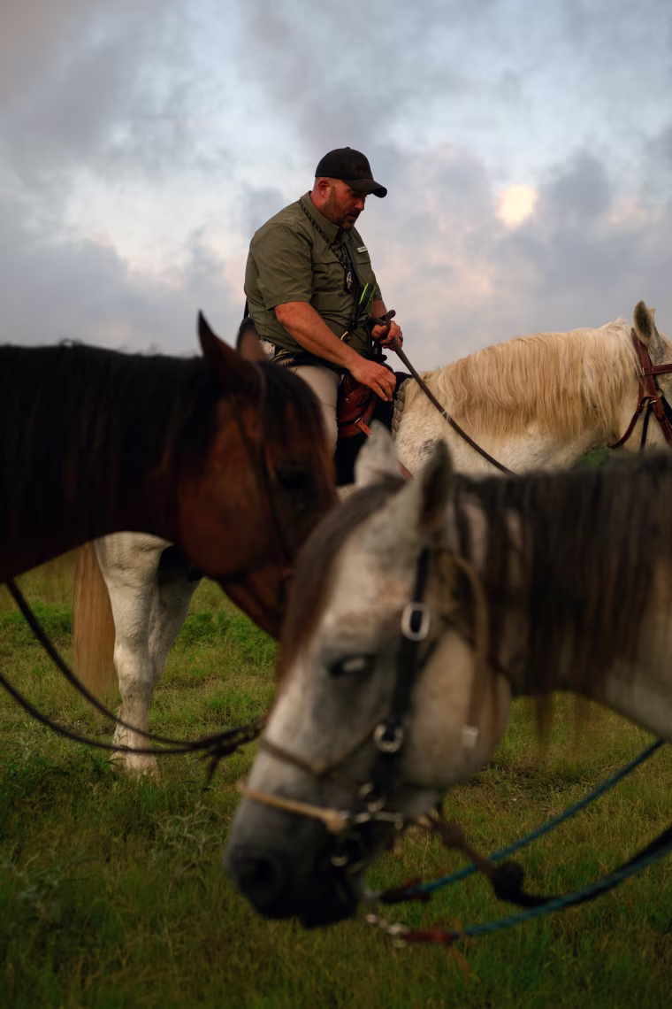 Matt McCrury sits on a horse, two other horses are in front of him in the foreground