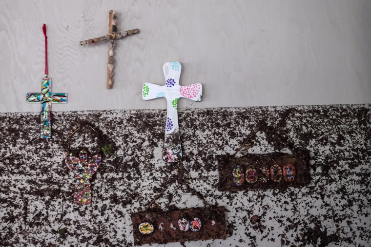 Crosses hang from a wall with flood marks
