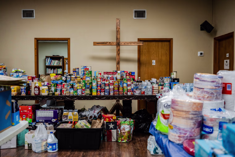 Food and other items inside of a room in front of a large cross