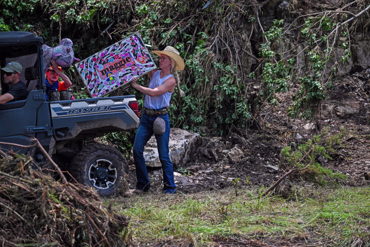 A girl's trunk and a stuffed animal are recovered along the the Guadalupe River near Camp Mystic on July 7, 2025 in Hunt, Texas.