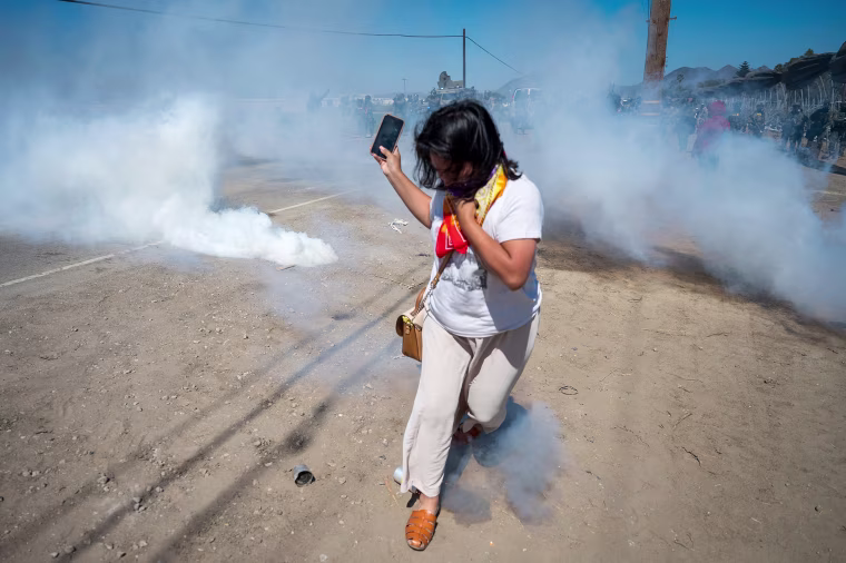 A protester runs from tear gas