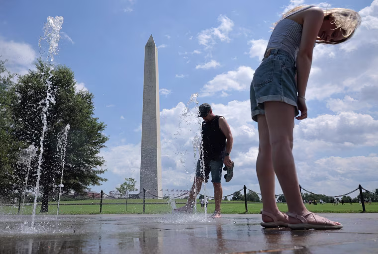 Tourists cool off in a fountain near the base of the Washington Monument on July 17, 2025 in Washington as the heat index climbed to over 100-degrees Fahrenheit. 
