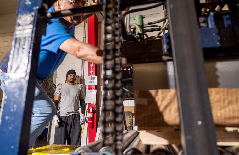Jose Zuniga, left, and Zach Powell run a printing press at Independent Can Co. in Belcamp, Md., on July 18. 
