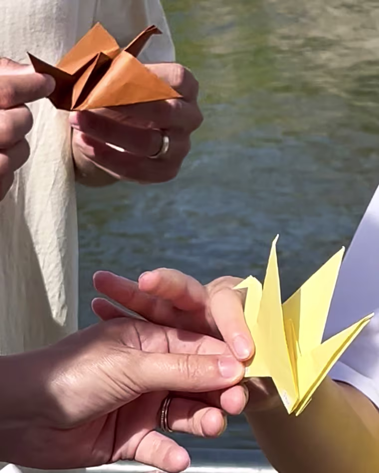 At the end of his tours, Sasaki, right, gives each person an origami crane symbolizing peace in Hiroshima.