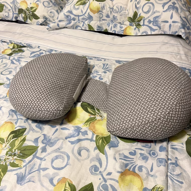 Momcozy wedge pillow on top of bedroom comforter