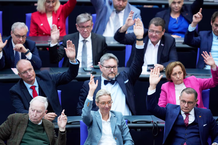 Members of the AfD faction with leader Alice Weidel, center,  raise their hands  during a vote