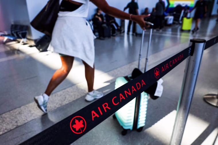 A passenger walk past an Air Canada line rope