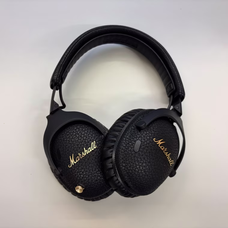Marshall Monitor III headphones sitting on a table.