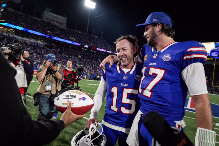 Josh Allen, right, with Matt Prater on the football field speak to reporters