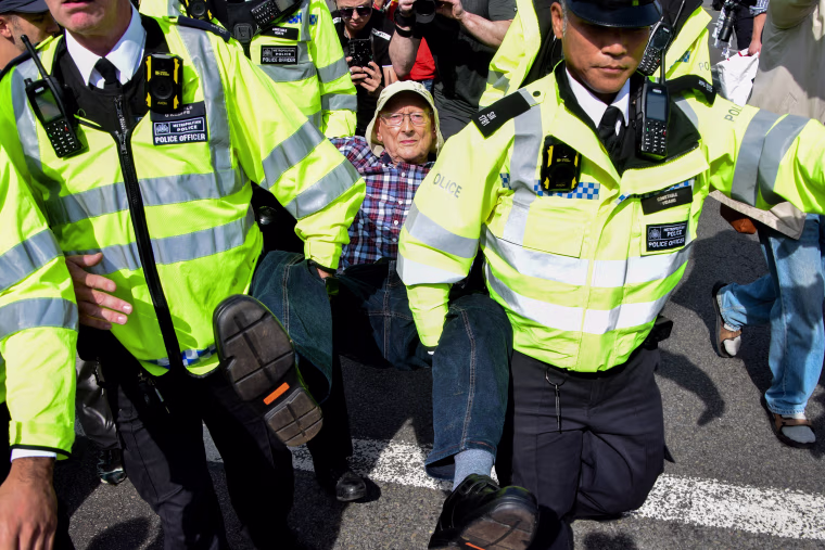 Police officers arrest a protester in Parliament Square who