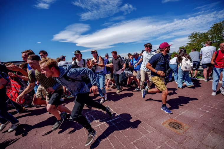 People run after a shot was fired at U.S. right-wing activist and commentator Charlie Kirk at a Utah Valley University speaking event in Orem