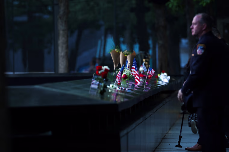 People pay tribute at the South Tower reflecting pool at the 9/11 Memorial and Museum at the World Trade Center complex, before the 9/11 commemoration ceremonies at Ground Zero in New York on September 11, 2025. 