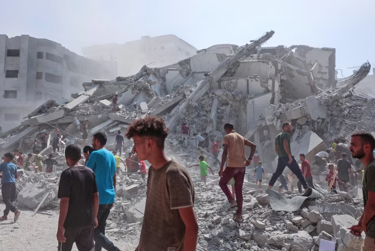 Palestinians search the rubble of al-Ghafari tower after its destruction by Israeli airstrikes in Gaza City on Sept. 15, 2025.