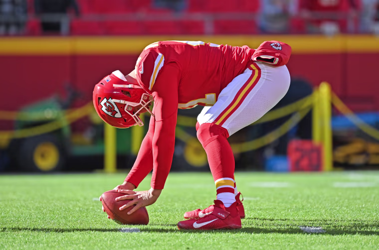 James Winchester curls down to the ground with a football on the field