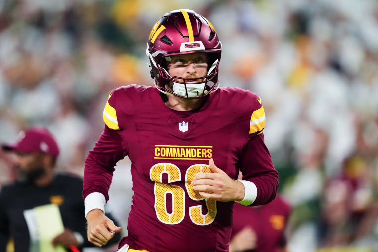Tyler Ott runs on the football field in his uniform and helmet