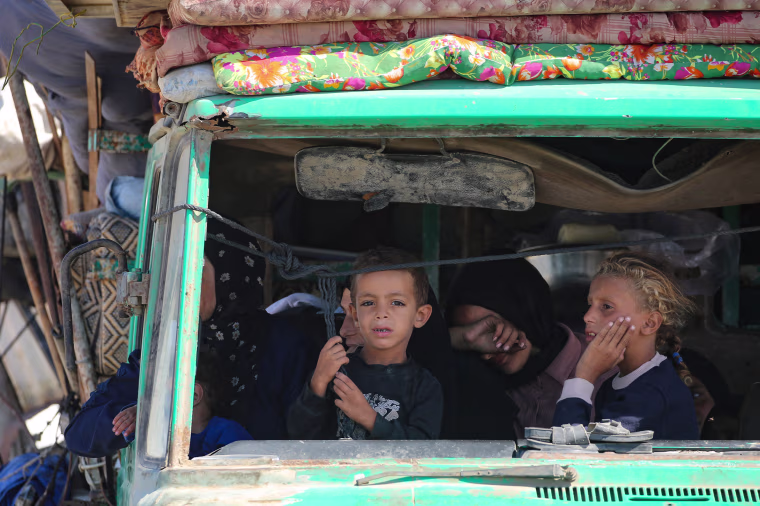 Palestinians from Gaza City ride in a truck as they move southwards with their belongings
