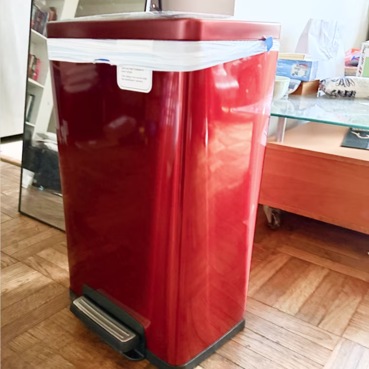 Photo of red can with trash bag in it