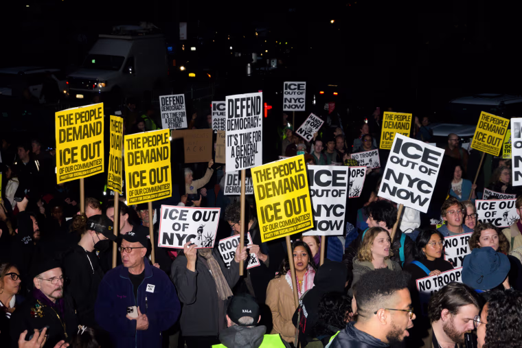 People hold anti-ICE signs outside