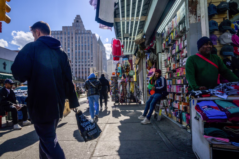 people walk on the street past vendors