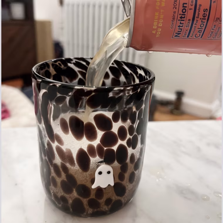 A hand pouring Recess’ Paloma into a glass cup.