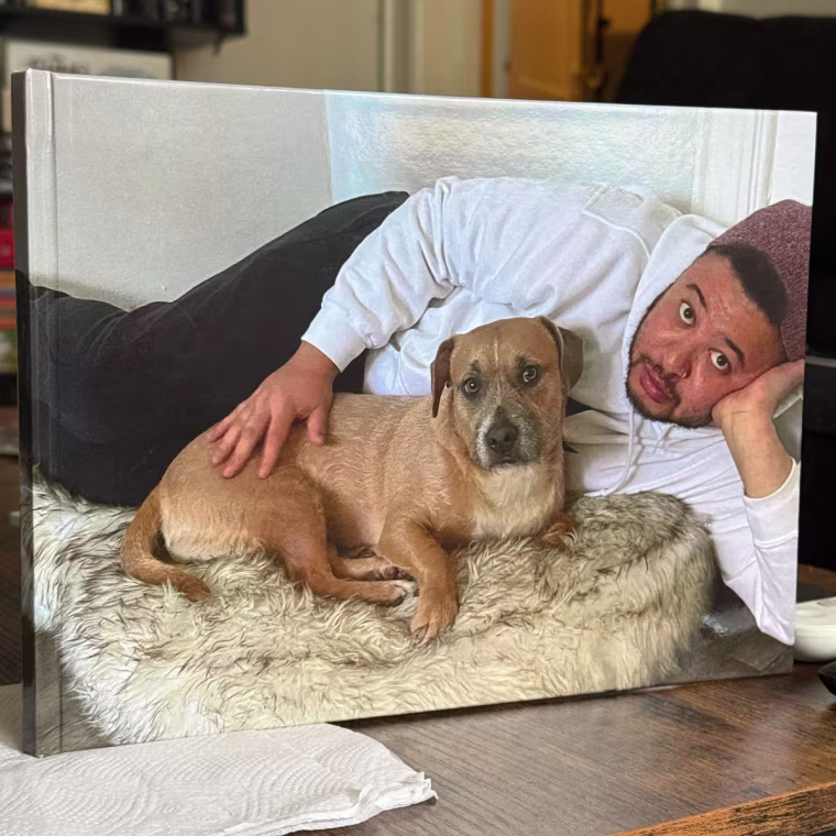 Man holding photo book with cover photo of him and his dog