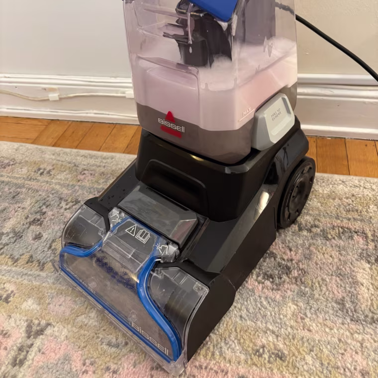 The dirty water tank of the Bissell TurboClean Pet Upright Carpet and Upholstery Cleaner filled with grey-colored solution.