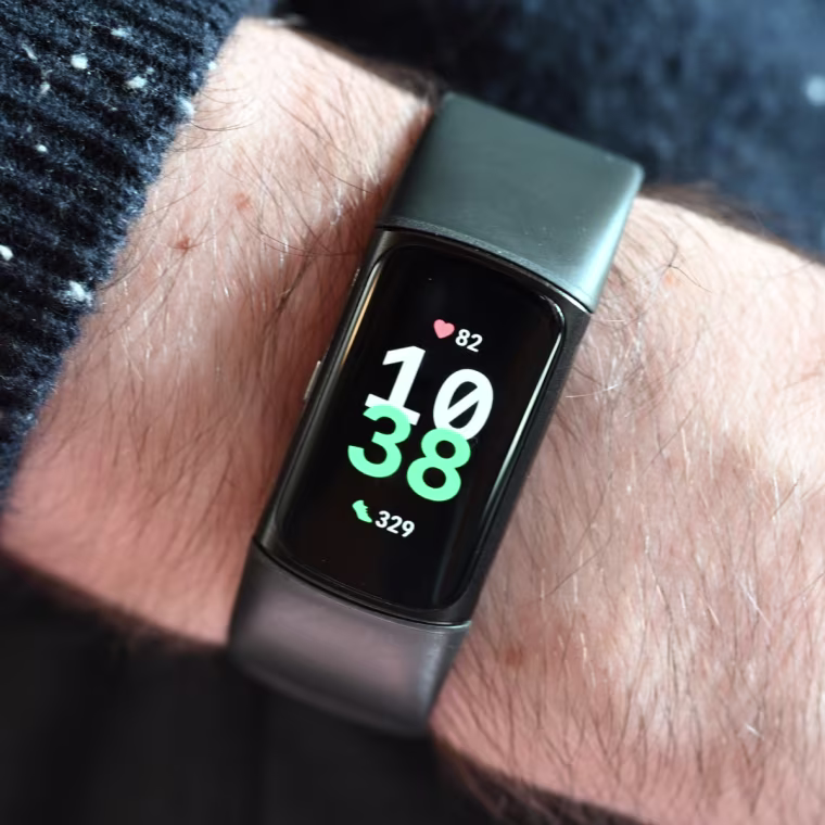 A close-up of the FitBit Charge 6, showing the time on the wrist of the writer.