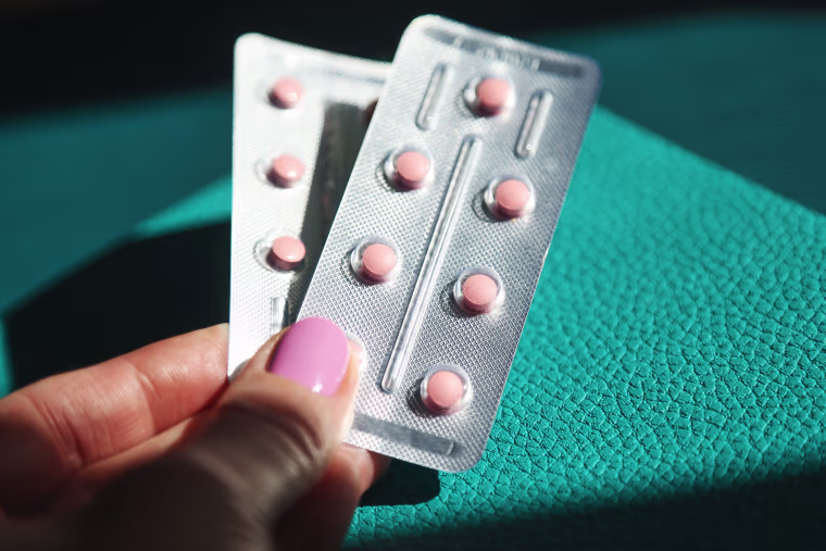 Woman's hands holding HRT pills