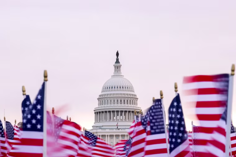 The U.S. Capitol with American flags waving in the foreground.