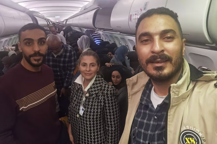 Hanan Jarrar, center, Palestinian ambassador to South Africa, smiles for a picture on a plane in Johannesburg, South Africa.