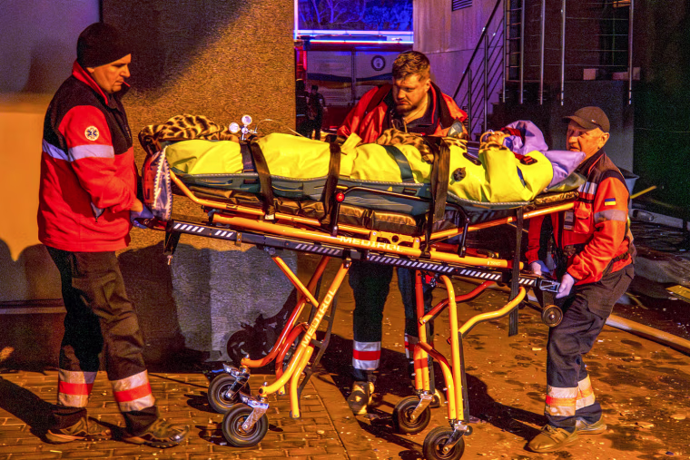 Rescue workers carry a person in a stretcher outside