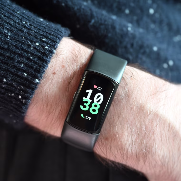 A close-up of the FitBit Charge 6, showing the time on the wrist of the writer.