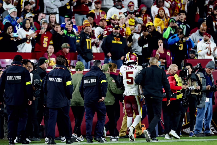 Jayden Daniels of the Washington Commanders is helped off the field after an injury during the second half of the NFL game against the Seattle Seahawks at Northwest Stadium on November 2 in Landover, Md.