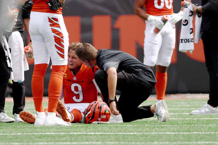 Joe Burrow of the Cincinnati Bengals is looked at by staff following an injury in the second quarter of the game against the Jacksonville Jaguars at Paycor Stadium on September 14 in Cincinnati, Ohio.