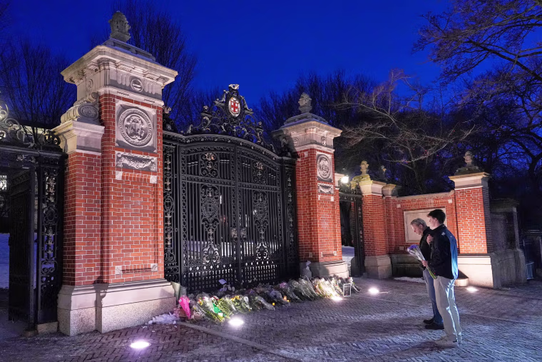 Visitors pause at a makeshift memorial at the Van Wickle Gate at Brown University 