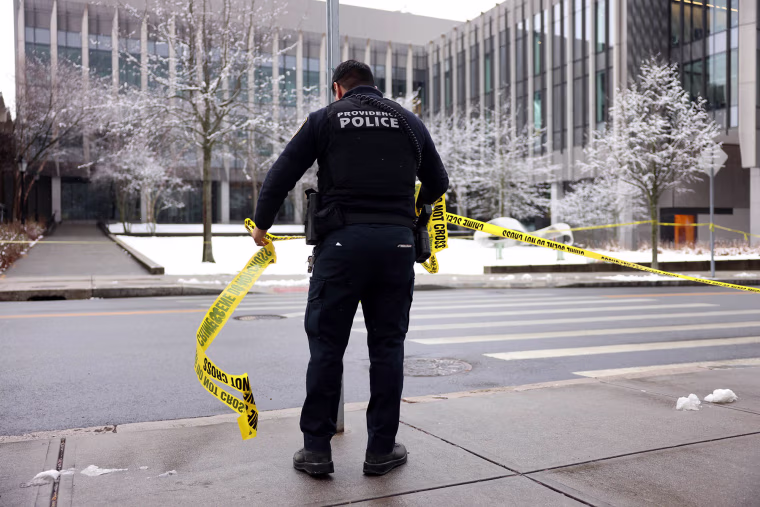 A Providence Police officer takes down crime scene tape across the street from Barus & Holley School at Brown University