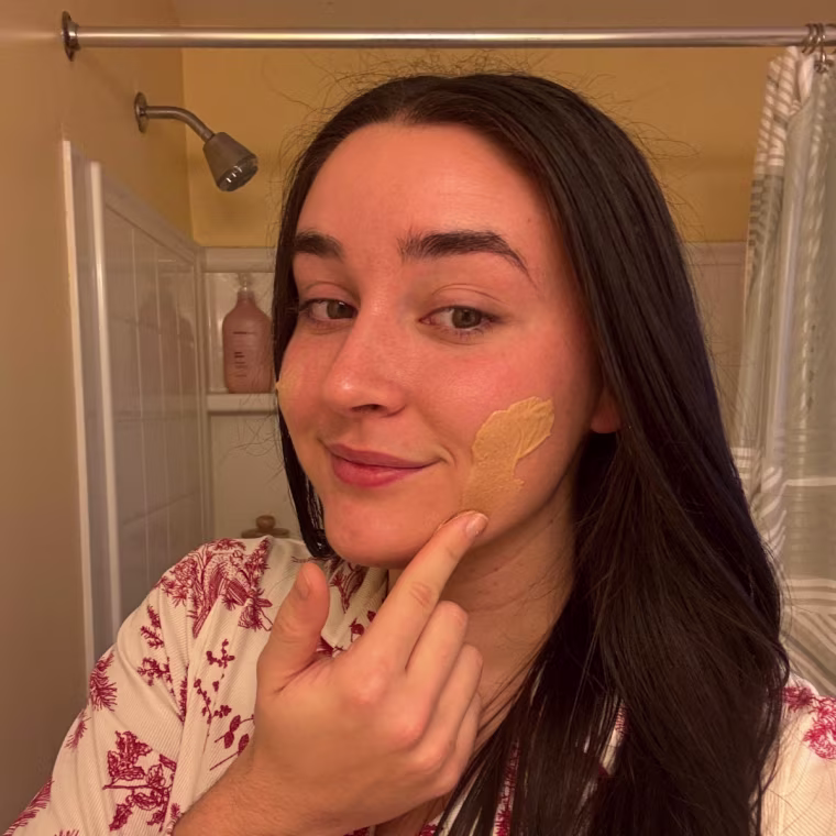 Woman applying tinted sunscreen on face