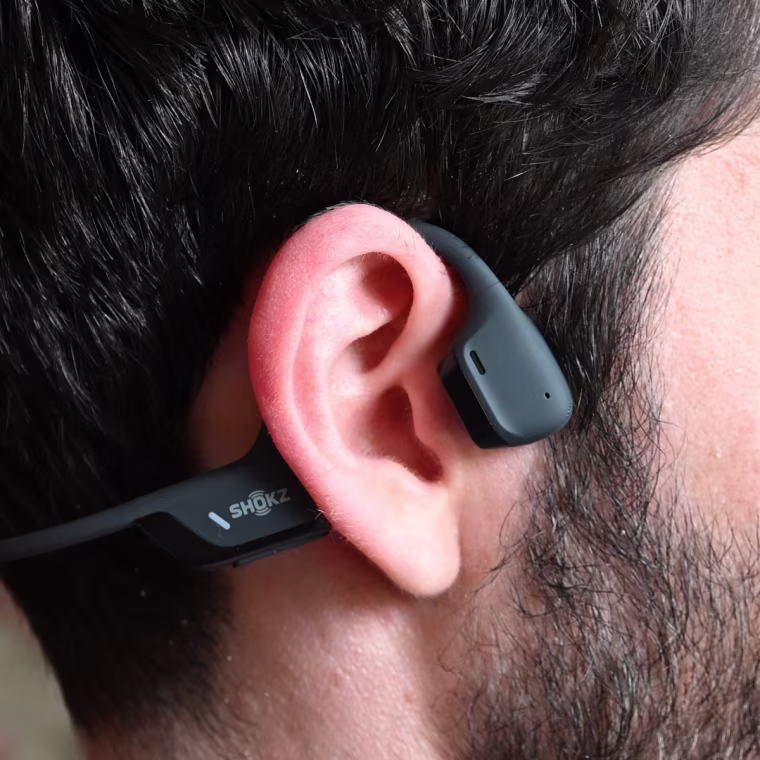A close up of a Shokz OpenRun Pro 2 headphones on the ear of the writer.