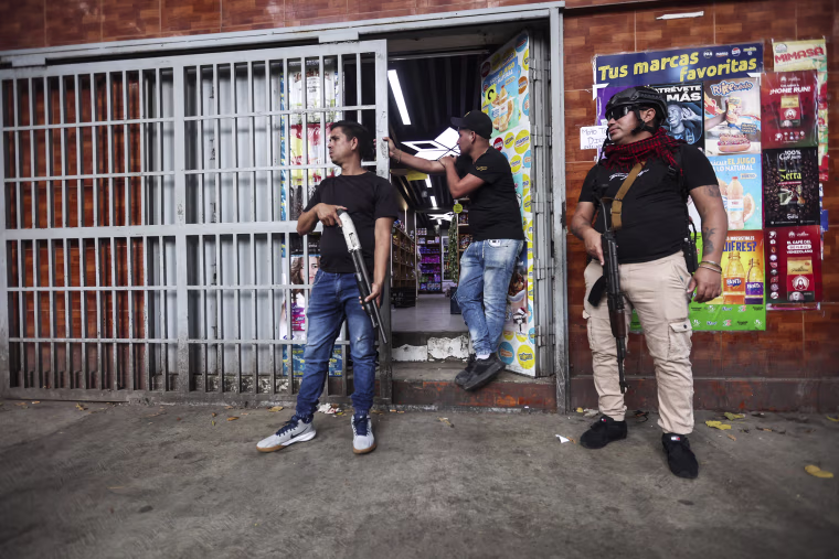 Image: Armed supporters of ousted Venezuelan President Nicolas Maduro stand guard