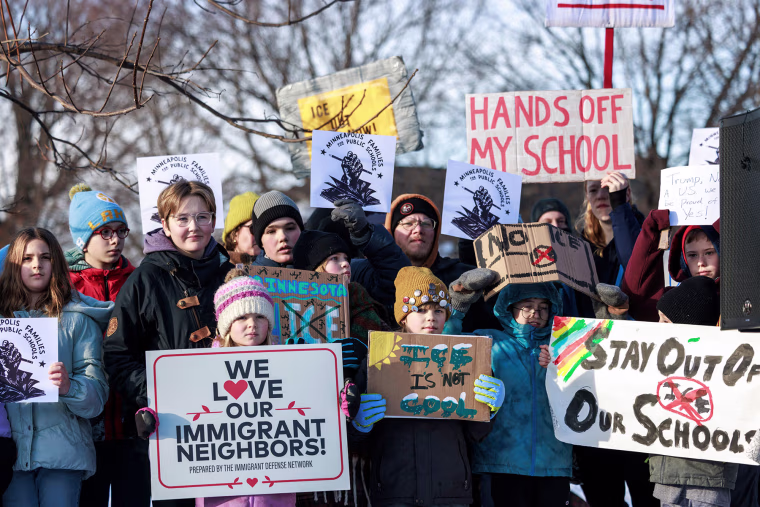 Minneapolis public school families, educators and students hold signs during a news conference at Lake Hiawatha Park in Minneapolis, on Friday, Jan. 9, 2026, demanding Immigration and Customs Enforcement be kept out of schools.