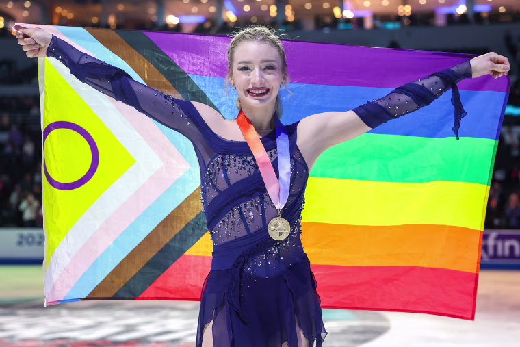 Image: Amber Glenn poses for a photo with a LGBTQIA+ flag during the Victory Ceremony 