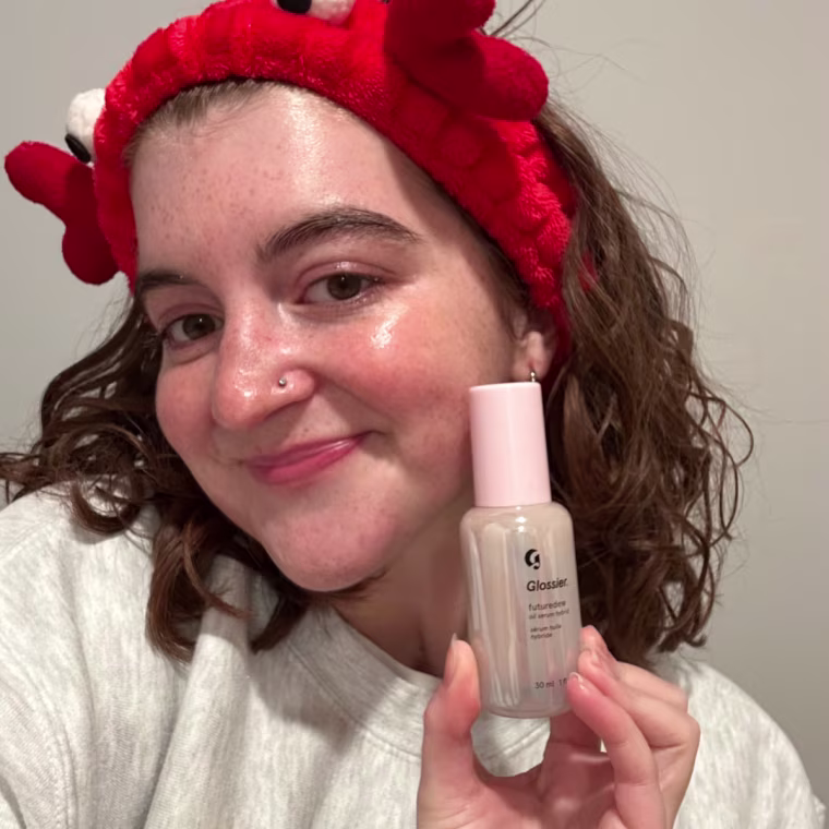 Woman holding Glossier Futuredew bottle.
