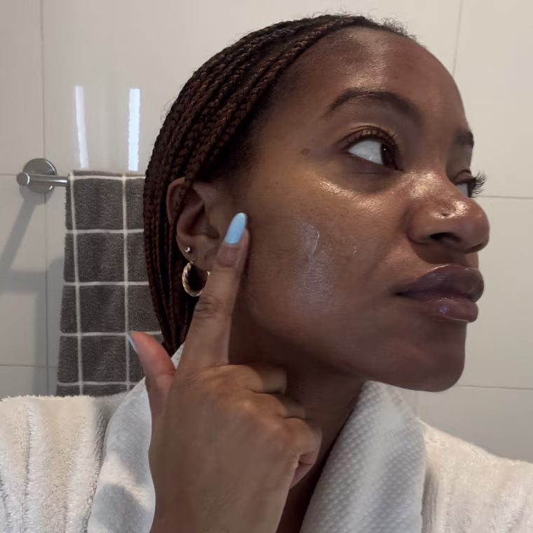 Woman applying serum to face