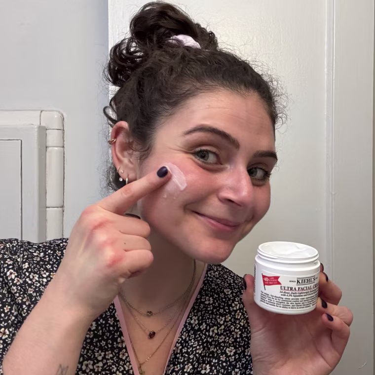 Woman applying cream on face.