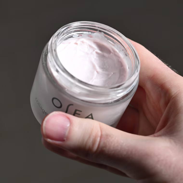 Man holding jar of moisturizer.